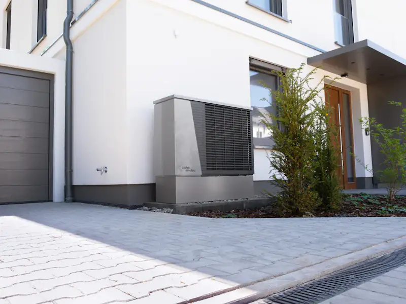 Pompe à chaleur installée devant une maison neuve