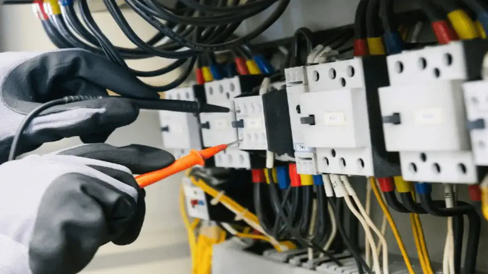 Électricien testant un tableau électrique au multimètre