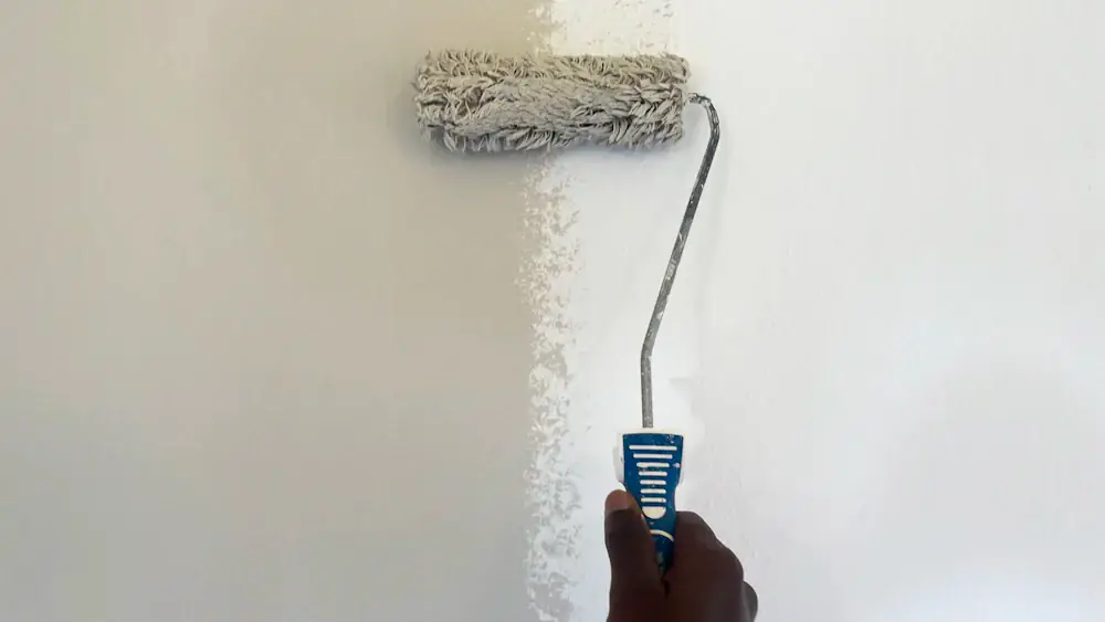 Rouleau de peinture blanche sur un mur