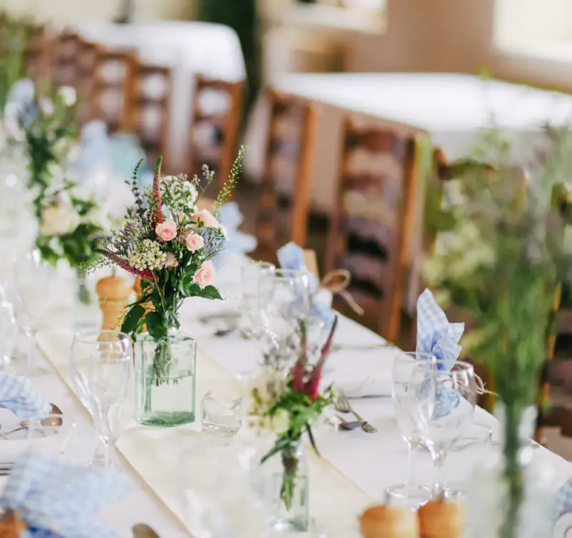 Grande table de réception dressée, bouquets champêtres