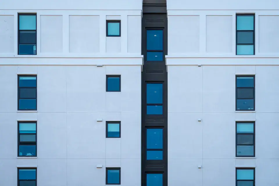 Façade claire aux fenêtres bleues de l'immeuble de l'office
